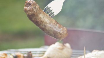Cook sausage on the grill for a family lunch.